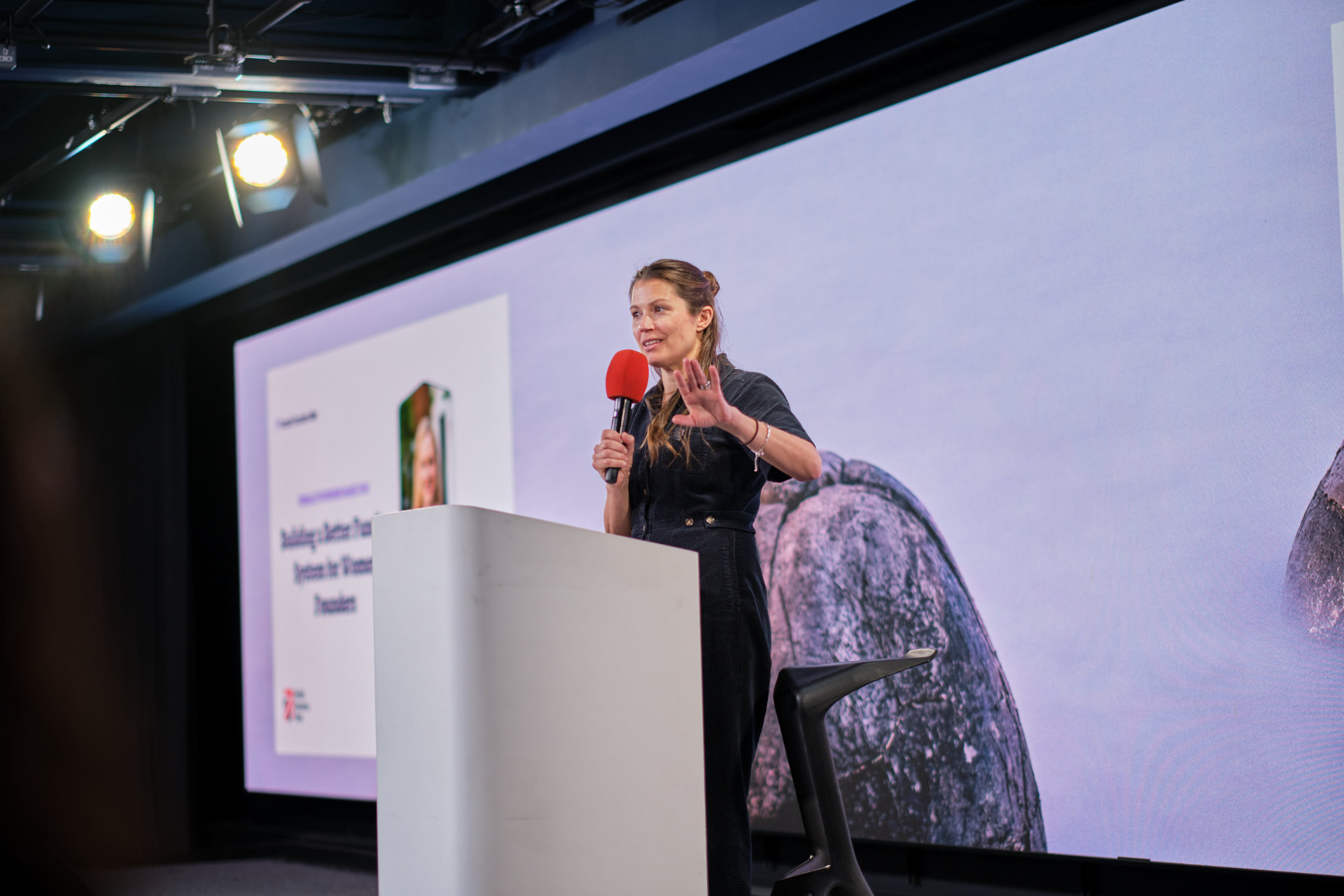 Emmie Faust speaking on stage at a founders event